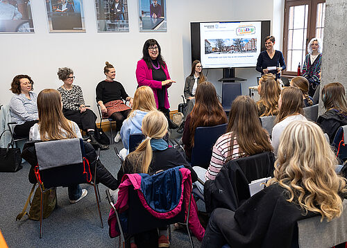 Rektorin Elizabeth Prommer begrüßt die Schülerinnen. Die Mädchen sitzen in einem Raum, ihnen gegenüber steht die Rektorin. Links und rechts von ihr sitzen weitere Professorinnen, die an der Veranstaltung teilgenommen haben.
